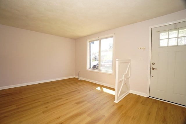 entrance foyer with baseboards and light wood finished floors