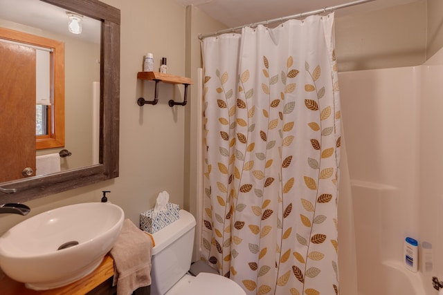 full bathroom featuring a shower with curtain, toilet, and a sink