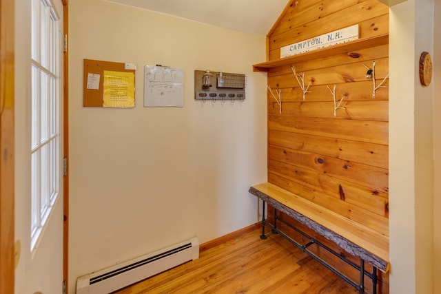 mudroom featuring a baseboard heating unit, lofted ceiling, baseboards, and wood finished floors