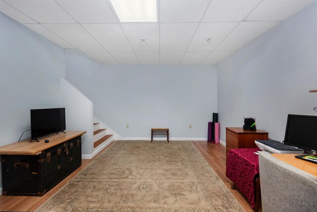 office with baseboards, wood finished floors, and a paneled ceiling