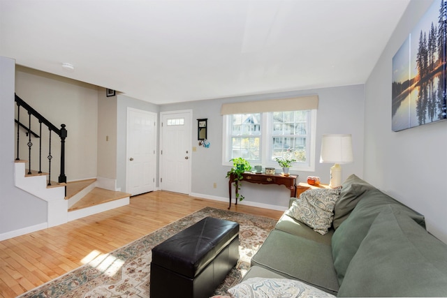 living room with stairs, wood finished floors, and baseboards