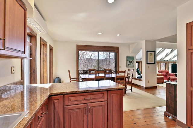 78 Coopers Trce, Plymouth, VT 05056 - kitchen with a wall mounted air conditioner, a peninsula, light wood finished floors, and plenty of natural light