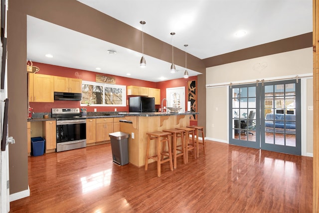 417 Locust St, Rollinsford, NH 03869 - kitchen featuring stainless steel range with electric cooktop, light brown cabinetry, freestanding refrigerator, under cabinet range hood, and dark countertops