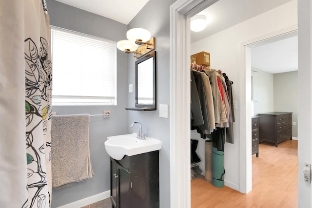 417 Locust St, Rollinsford, NH 03869 - bathroom with wood finished floors, vanity, baseboards, and a walk in closet