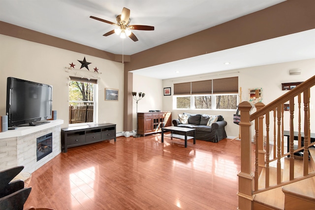 417 Locust St, Rollinsford, NH 03869 - living room featuring a ceiling fan, stairs, wood finished floors, and a glass covered fireplace