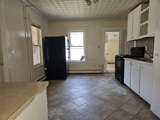 kitchen featuring white cabinets, black appliances, and a healthy amount of sunlight