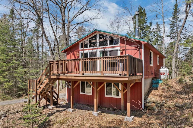 rear view of property featuring stairway and a deck