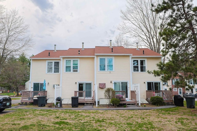 back of property featuring a yard and a wooden deck