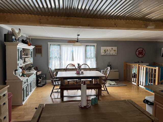 dining area featuring beam ceiling and light wood-type flooring