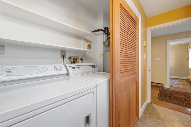 washroom featuring separate washer and dryer, laundry area, baseboard heating, baseboards, and light wood-type flooring