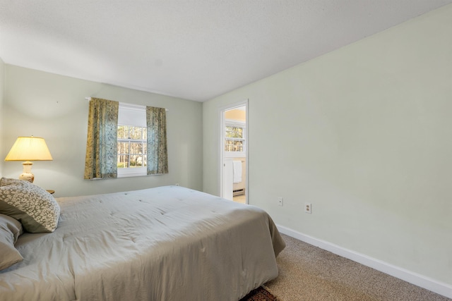 carpeted bedroom with a baseboard heating unit and baseboards