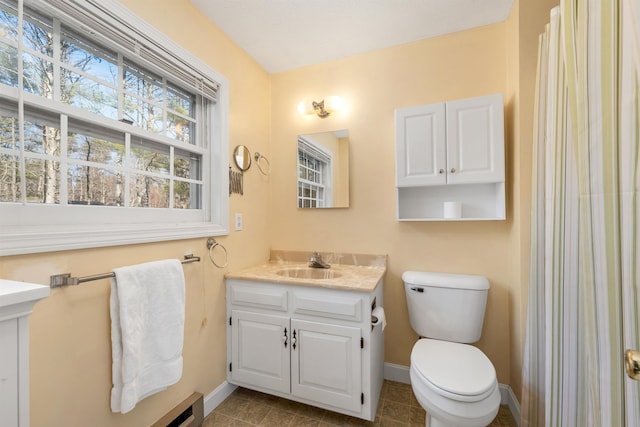 bathroom with baseboards, toilet, tile patterned flooring, and vanity