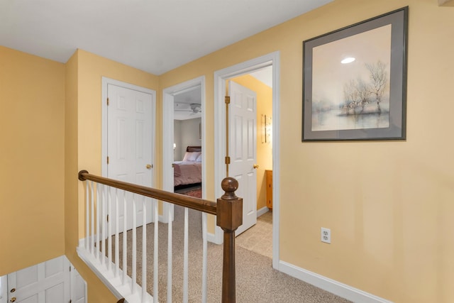 corridor featuring baseboards and carpet