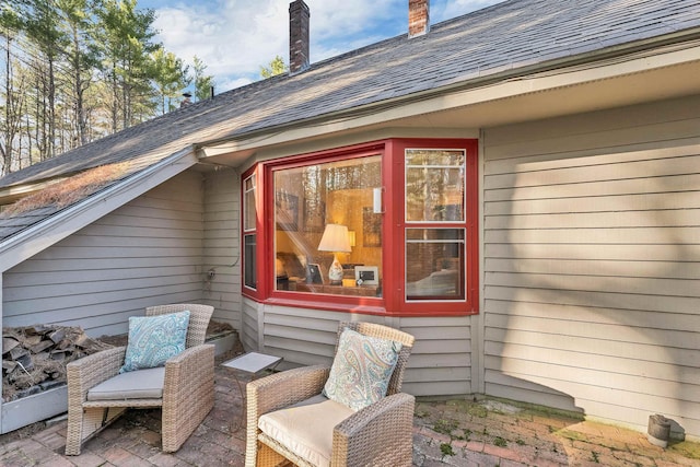 exterior space with a patio and roof with shingles
