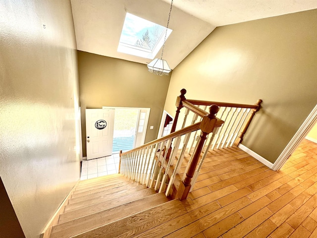 207 Blakely Farm Rd, Colebrook, NH 03576 - staircase with lofted ceiling with skylight, wood finished floors, and baseboards
