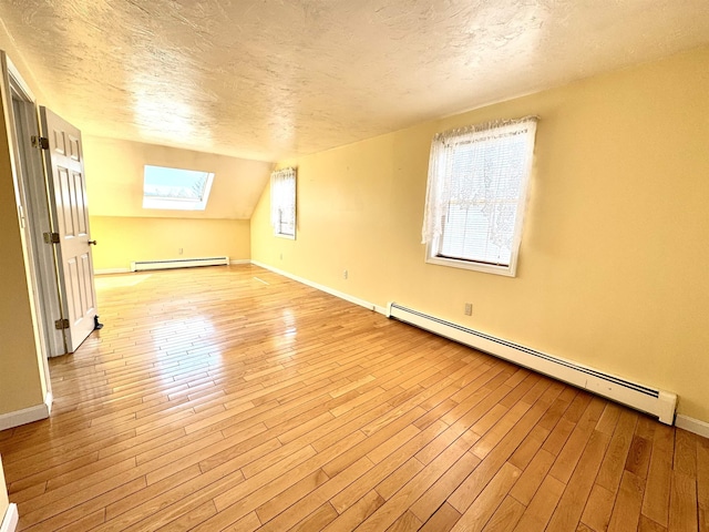 207 Blakely Farm Rd, Colebrook, NH 03576 - additional living space featuring a baseboard radiator, light wood-type flooring, a baseboard heating unit, and a textured ceiling