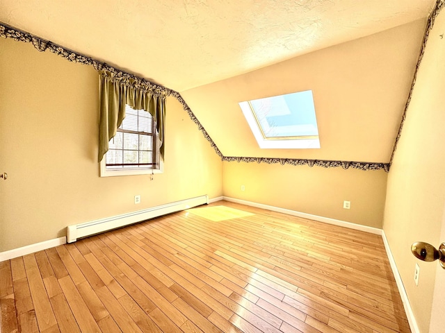 207 Blakely Farm Rd, Colebrook, NH 03576 - additional living space with a baseboard heating unit, wood finished floors, and baseboards
