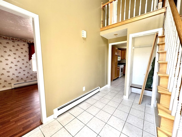 207 Blakely Farm Rd, Colebrook, NH 03576 - interior space featuring baseboards, stairs, light tile patterned flooring, and a baseboard radiator