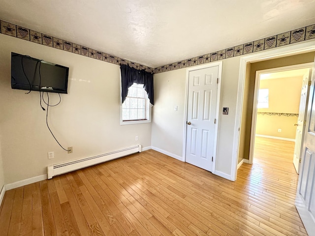 207 Blakely Farm Rd, Colebrook, NH 03576 - unfurnished bedroom with baseboards, light wood-style flooring, and a baseboard radiator