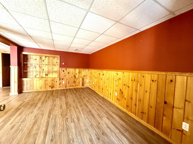 207 Blakely Farm Rd, Colebrook, NH 03576 - spare room with baseboards, wood finished floors, a wainscoted wall, and a drop ceiling