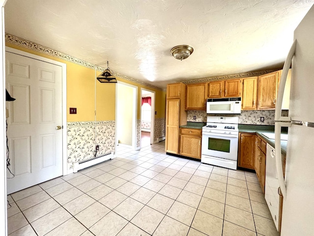 207 Blakely Farm Rd, Colebrook, NH 03576 - kitchen with brown cabinets, a baseboard radiator, dark countertops, light tile patterned flooring, and white appliances
