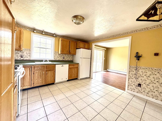 207 Blakely Farm Rd, Colebrook, NH 03576 - kitchen with a sink, white appliances, dark countertops, a textured ceiling, and baseboard heating