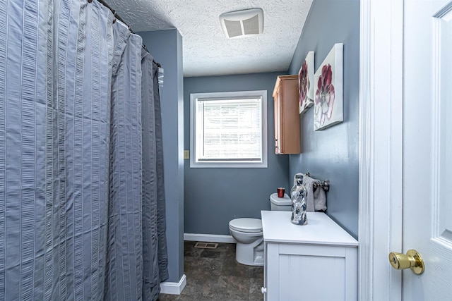bathroom with a textured ceiling, stone finish flooring, visible vents, baseboards, and toilet