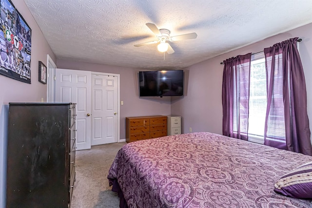 carpeted bedroom featuring a textured ceiling and ceiling fan