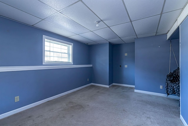 spare room with a drop ceiling, carpet, and baseboards