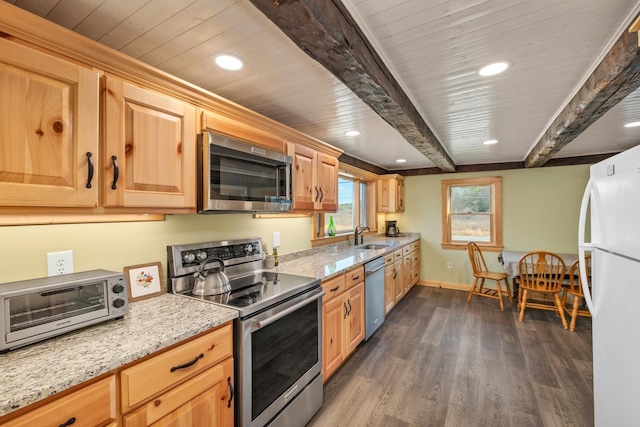 kitchen featuring a toaster, light stone countertops, dark wood-style flooring, and appliances with stainless steel finishes