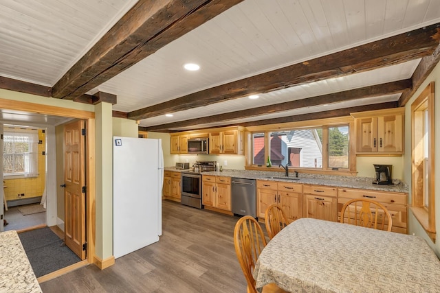 kitchen featuring a sink, stainless steel appliances, baseboard heating, beam ceiling, and wood finished floors