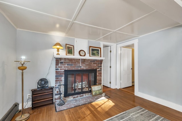 living area with baseboard heating, baseboards, wood finished floors, and a brick fireplace