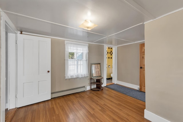 entrance foyer featuring baseboard heating, baseboards, and wood finished floors