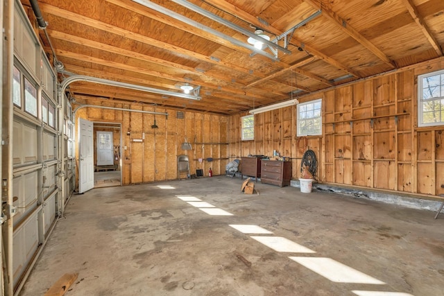 misc room featuring concrete floors, a garage, and a healthy amount of sunlight