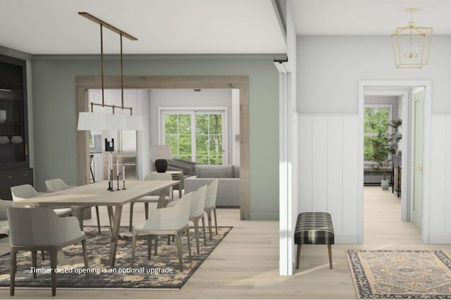 dining space with a wealth of natural light, crown molding, light wood-style flooring, and a notable chandelier