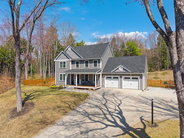 view of front of home featuring driveway, fence, a porch, and an attached garage