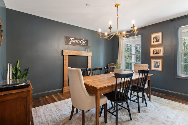dining area with an inviting chandelier, wood finished floors, and baseboards
