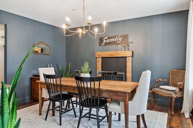dining space featuring a notable chandelier, wood finished floors, and baseboards