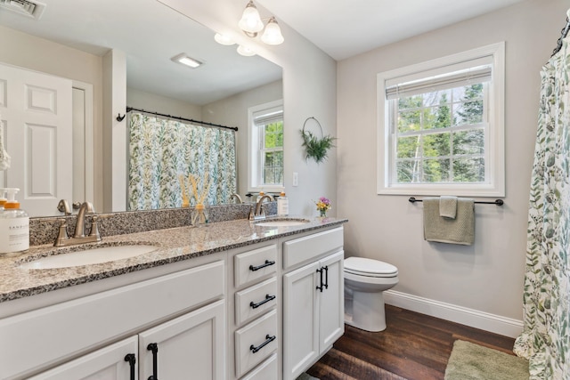 full bath featuring a sink, baseboards, wood finished floors, and visible vents