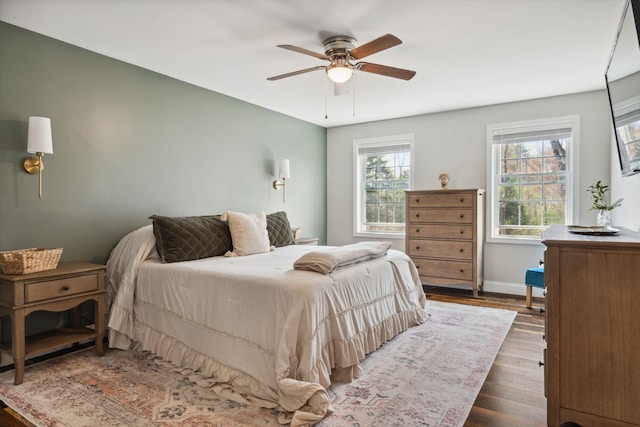 bedroom featuring wood finished floors, a ceiling fan, and baseboards