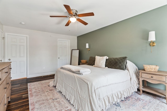 bedroom featuring ceiling fan, baseboards, and dark wood finished floors