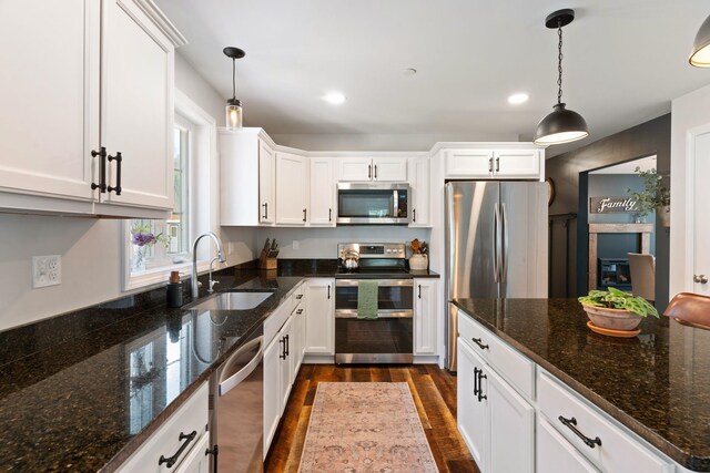 kitchen featuring dark wood-style floors, a sink, white cabinetry, and stainless steel appliances