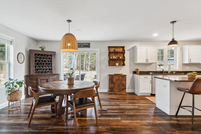 dining space featuring baseboards, dark wood-style flooring, and plenty of natural light