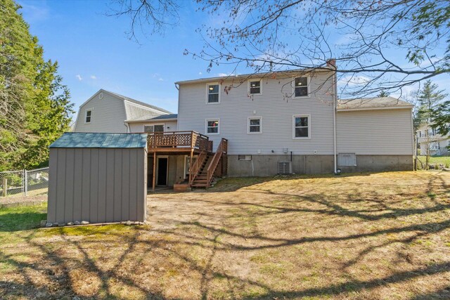 back of property featuring stairs, a deck, a chimney, fence, and a yard
