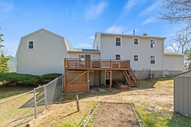 rear view of house featuring a wooden deck, a fenced backyard, cooling unit, stairs, and a chimney