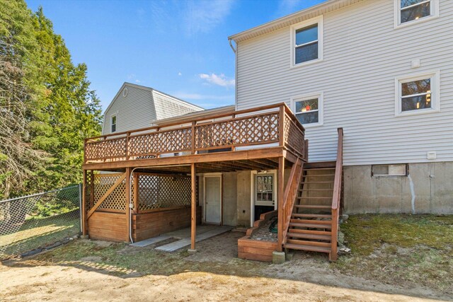 back of house featuring fence, a wooden deck, and stairs
