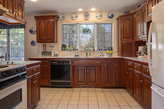 kitchen featuring a sink, visible vents, freestanding refrigerator, dishwasher, and stove