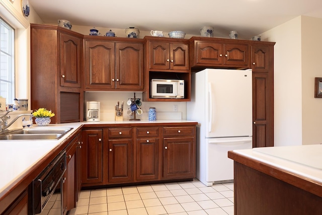 kitchen featuring light tile patterned floors, white appliances, light countertops, and a sink