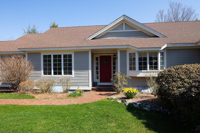 ranch-style house with a front lawn and roof with shingles