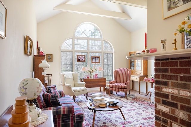 sitting room with beam ceiling, high vaulted ceiling, and wood finished floors
